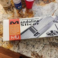 Box front showing brand MIU and mandoline slicer image with product details and dishwasher safe note.