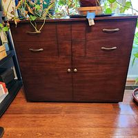 Front view of closed mahogany Murphy bed cabinet showing four upper drawers and two cabinet doors below with brass and round handles.