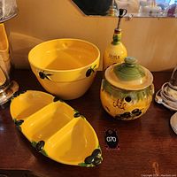 Full view of ceramic set including large bowl, divided olive-shaped platter, ceramic garlic holder jar, and oil dispenser bottle with olive motifs