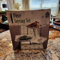 Box showing set name and usage example with food items on platters and stands.