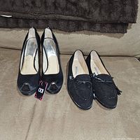 Photo of both pairs of shoes, Michael Kors peep toe heels on left, Manolo Blahnik loafers on right, showing overall condition.