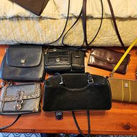 All six purses arranged on a wooden surface showing overall lot contents and designs