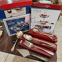 Overview of silver plated serving utensils and boxed items including the flatware caddy, dessert servers, and the three tier tower.