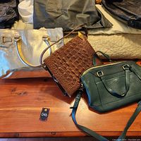 Photo of the three purses displayed on a wooden surface showing overall size and color differences.