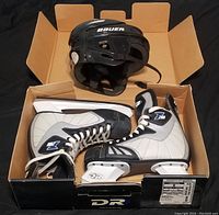 Top down photo of the black Bauer hockey helmet sitting on an open box containing the DR Z200 hockey skates in size 8.