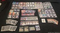 Overview of the collection laid out on a black surface showing various insert cards, including multiple rows of rookie and Hall of Fame cards in protective sleeves.