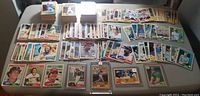Wide view of over 400 O-Pee-Chee vintage Canadian baseball cards spread out on table, showing multiple stacks and rows of cards with various player images and colors.