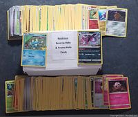 Top view of a large assortment of Pokémon cards, many featuring holographic effects, displayed around a white box labeled 'Pokémon Reverse Holo & Promo Holo Cards'.