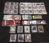 Multiple pages of Star Wars trading cards in protective sleeve pages with some cards loose below showing characters and various Star Wars themes.