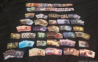 Over 70 cards laid out face-up showing various full-art designs and Japanese text, illustrating the variety of creatures and landscapes depicted in the cards.