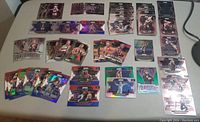 Various colorful wrestling cards including WWE and AEW brands, with holographic foil accents laid out on a flat surface.