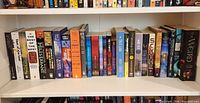 Two full shelves of various science fiction and fantasy books arranged upright by spine.