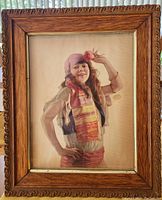 Framed antique calendar print showing full view of wooden carved frame and print inside.