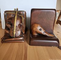 Front view of plaster violin bookend and wooden duck bookend showing details and texture.