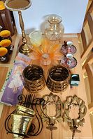 Full lot overview showing various brass and metal candle holders, decorative glass, small cups, and incense packages.