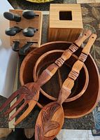 Wood bowls, carved wooden utensils, bamboo tissue box, and Henckels knife block with knives.
