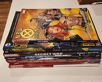 Stack of graphic novels showing covers for New X-Men, Secret War, The Walking Dead Vol 1 and 2, Civil War, Superman All-Star, House of M
