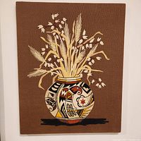 Front view of the large vintage embroidery showing the vase and plants design.