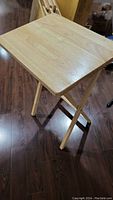 Single wooden TV tray set up with light natural wood grain finish and foldable legs