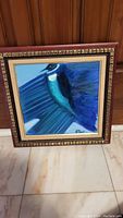 Original painting of a blue bird in blues and teals, framed in a carved brown wooden frame with gold trim inside