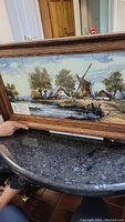 Wide view of oak framed hand-painted ceramic tiles depicting Dutch windmills and rural landscape.
