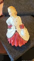 Front view of Royal Doulton porcelain figurine showing woman in white ermine coat and red dress