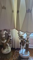 Full view of both vintage Limousin porcelain lamps with pleated shades set together showing overall design and scale.