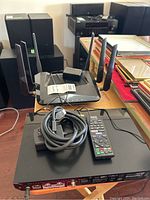 D-Link DIR-X4860 router aerial views showing router and cables on table with stereo speakers in background.