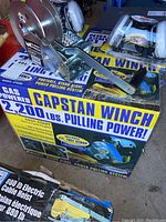 Manual hand winch and respirators resting on unopened gas-powered capstan winch box