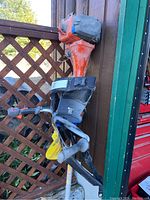 Photo showing the upper part of the Husqvarna pole saw including the orange and black engine and the handled back brace.