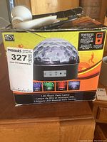 Photo of product box showing LED music party lamp with dome-shaped faceted cover and control panel.