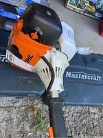 Close-up of orange-and-white engine housing and translucent fuel tank on Mastercraft case