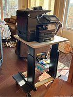 Printer and folding table on wheeled dolly in living room
