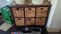 Front view showing entire wooden shelf unit with six woven wicker drawers in two rows of three