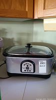 Front view of the Braavetti Professional slow cooker showing stainless steel body and glass lids.