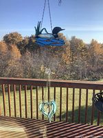Loon and heart wings suncatchers hanging with trees in background