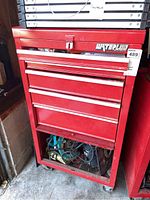 Front view of red Waterloo tool chest with five drawers and lower cupboard containing miscellaneous items.