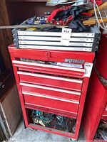 Red metal Watpiles tool chest with multiple drawers and gloves on top