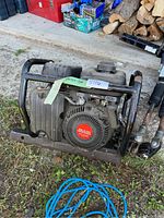 Front-left angle showing recoil starter, engine housing, and tubular frame