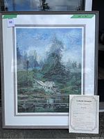 Full view of framed artwork showing waterfront landscape and accompanying certificate inside frame.