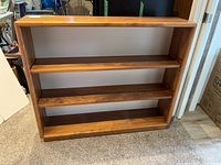 Front view of the wood bookshelf showing the three adjustable shelves and overall rectangular shape.