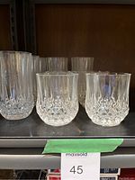 Photo showing 2 shorter cut crystal glasses with diamond pattern and faceting on the bottom half.
