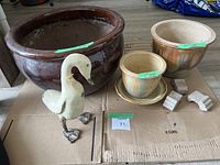 Large dark brown pot, two smaller brown and cream gradient pots with saucer, decorative duck figurine, and four pot feet