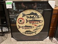 Framed serigraph print of stylized salmon in black and red on beige paper, matted and in glass frame