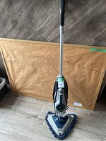 Full view of Hoover SteamScrub 2-in-1 Pet steamer standing upright on floor with mop pad attached.