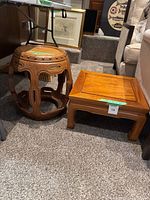 Both tables together showing the round carved tea table and the square end table in warm medium wood tones.