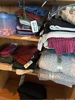 shelf of folded Aran Crafts knit scarves and throws