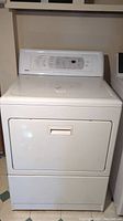 Front view of white Kenmore dryer showing door and top control panel.