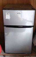 Front view of Walsh silver and black mini fridge with two doors and auction sticker showing lot number 386