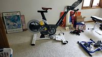 Overall left-side view of black and white ProForm Le Tour de France exercise bike in room.